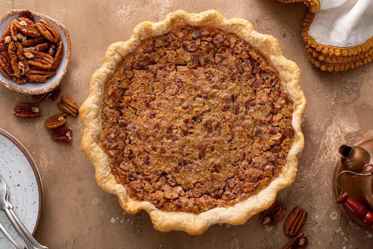 Baked pecan raisin pie cooling on a countertop.