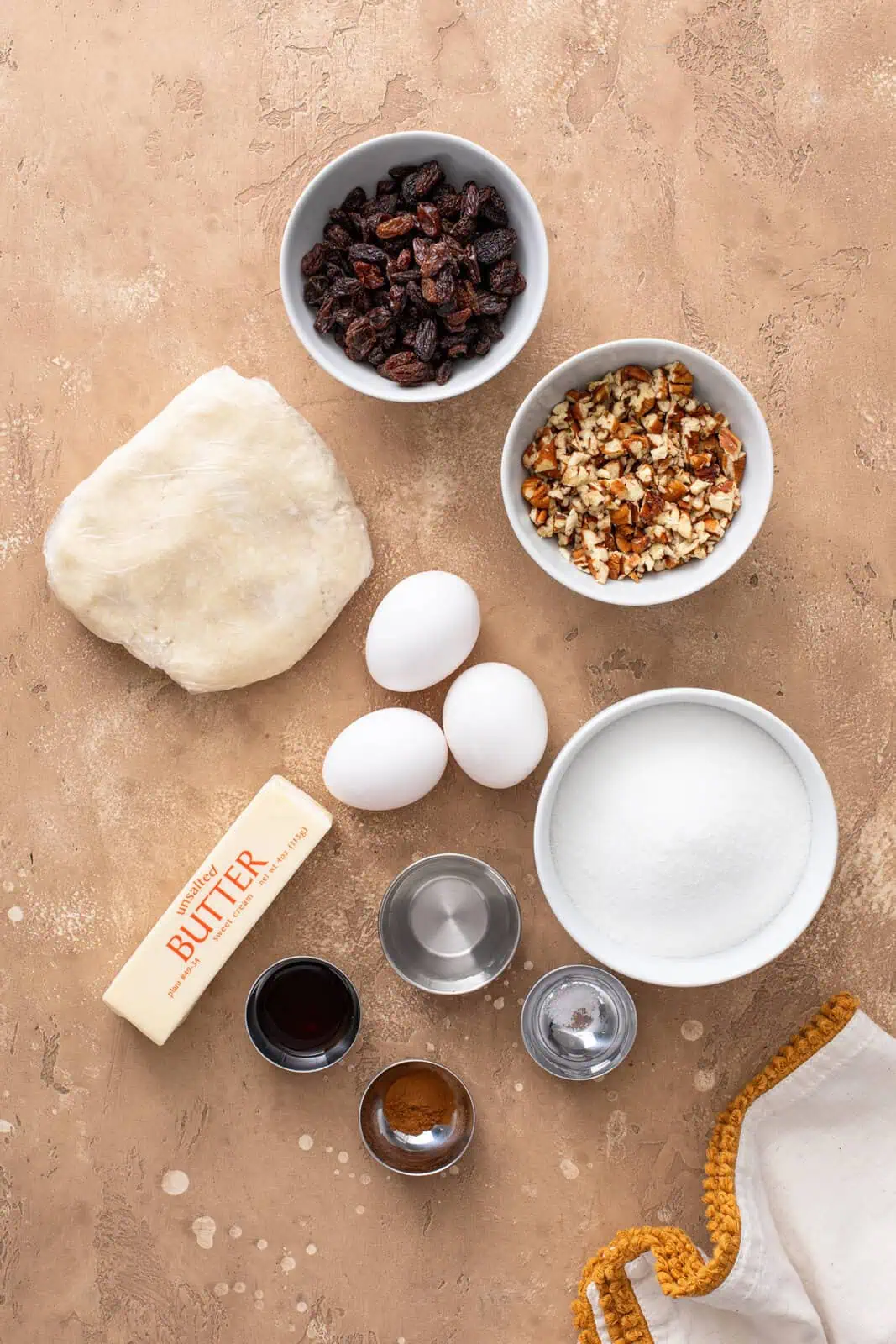 Ingredients for pecan raisin pie arranged on a countertop.