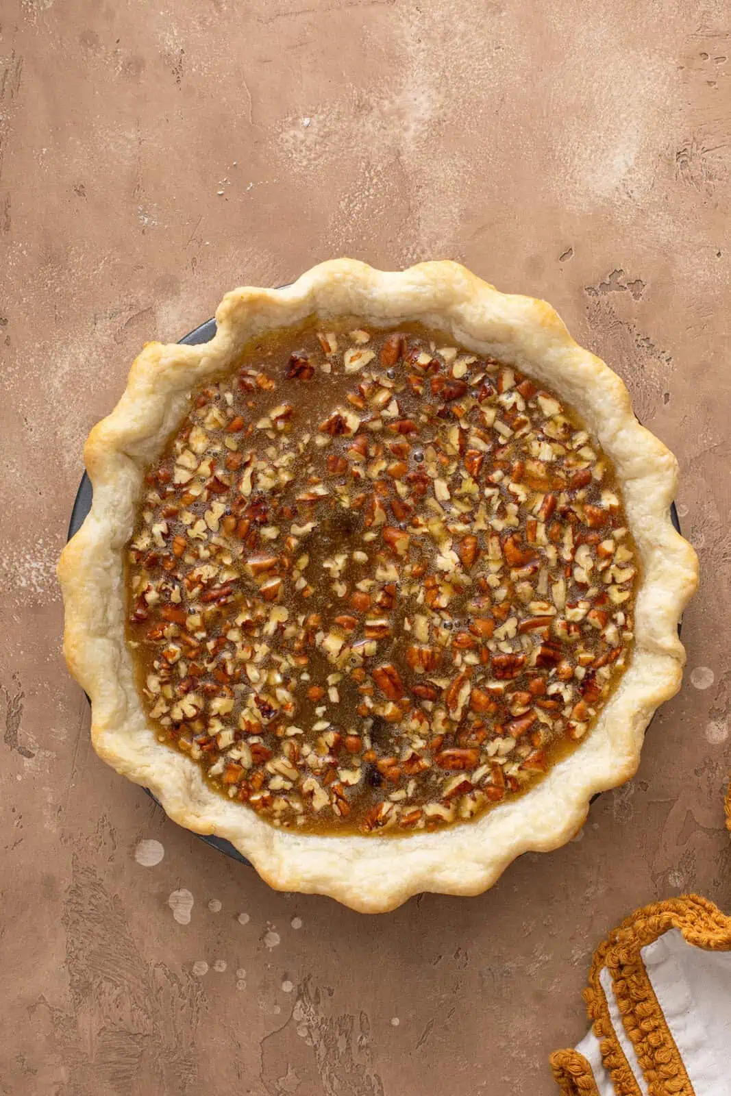 Unbaked pecan raisin pie ready to go in the oven.