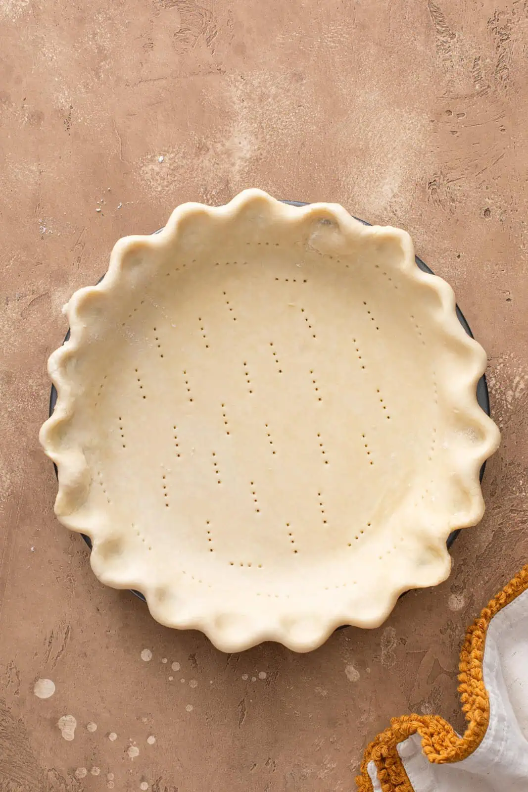 Unbaked pie crust in a pie plate, ready to be blind baked.