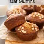 Banana oat muffins topped with rolled oats on a board in front of a glass of milk. Text overlay includes recipe name.