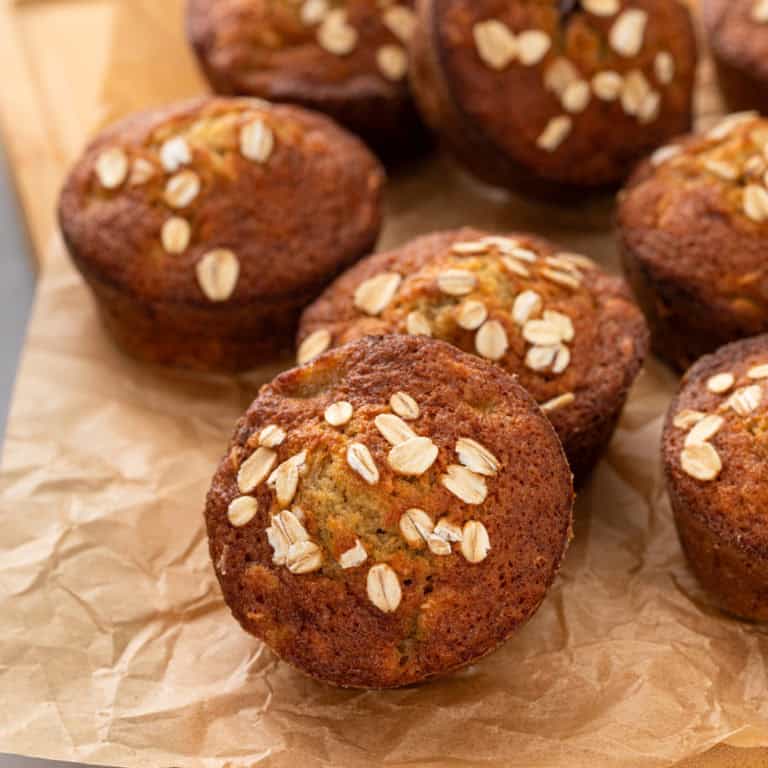 Cooled banana oat muffins on a piece of parchment paper.