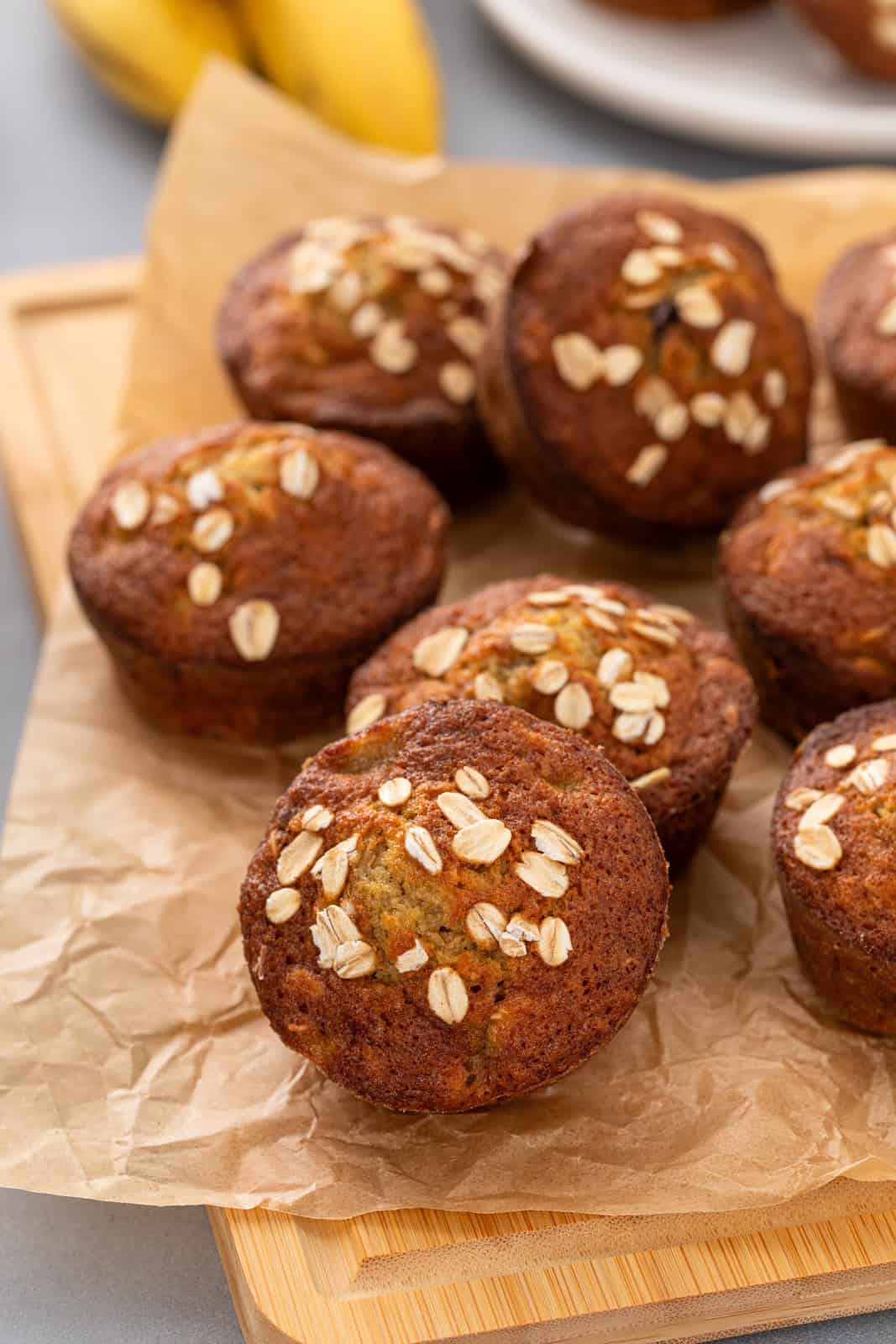 Banana oat muffins arranged on a piece of parchment paper.