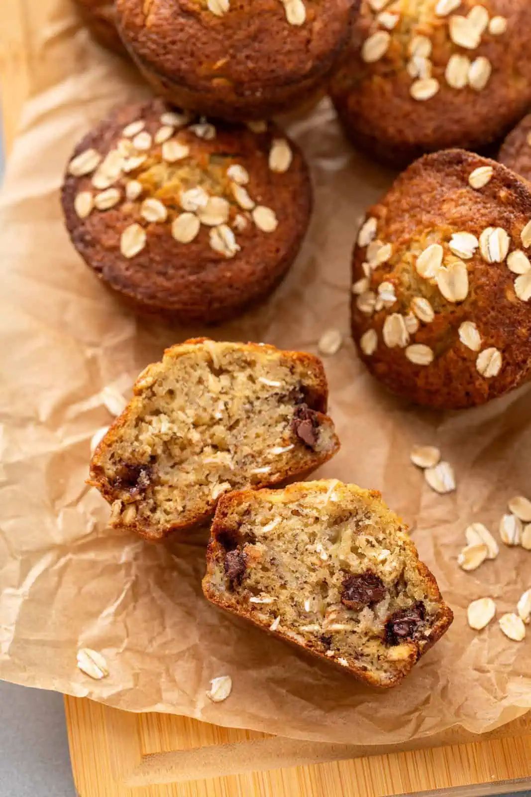 Halved banana oat muffin on a piece of parchment paper.