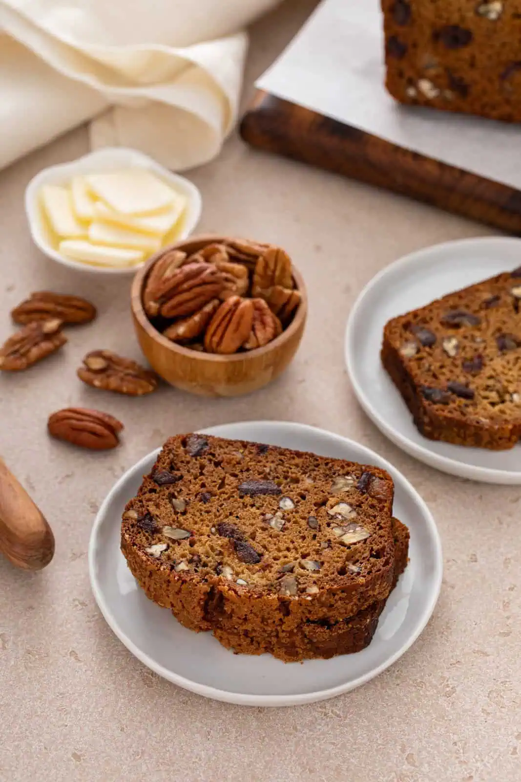 White plates, each holding slices of date nut bread.