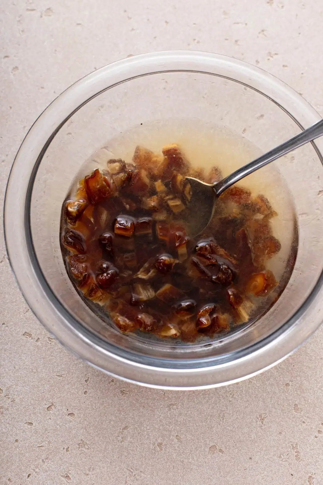 Dates soaking in water in a bowl.