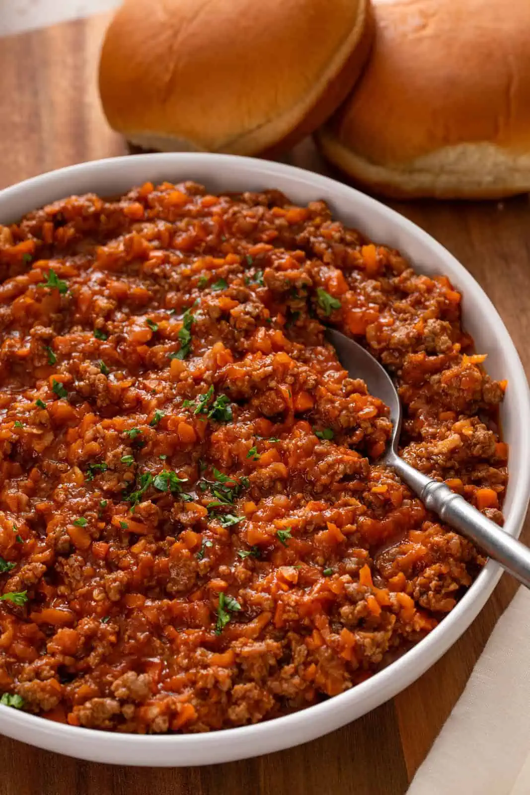 Close up of sloppy joe meat in a white serving bowl.