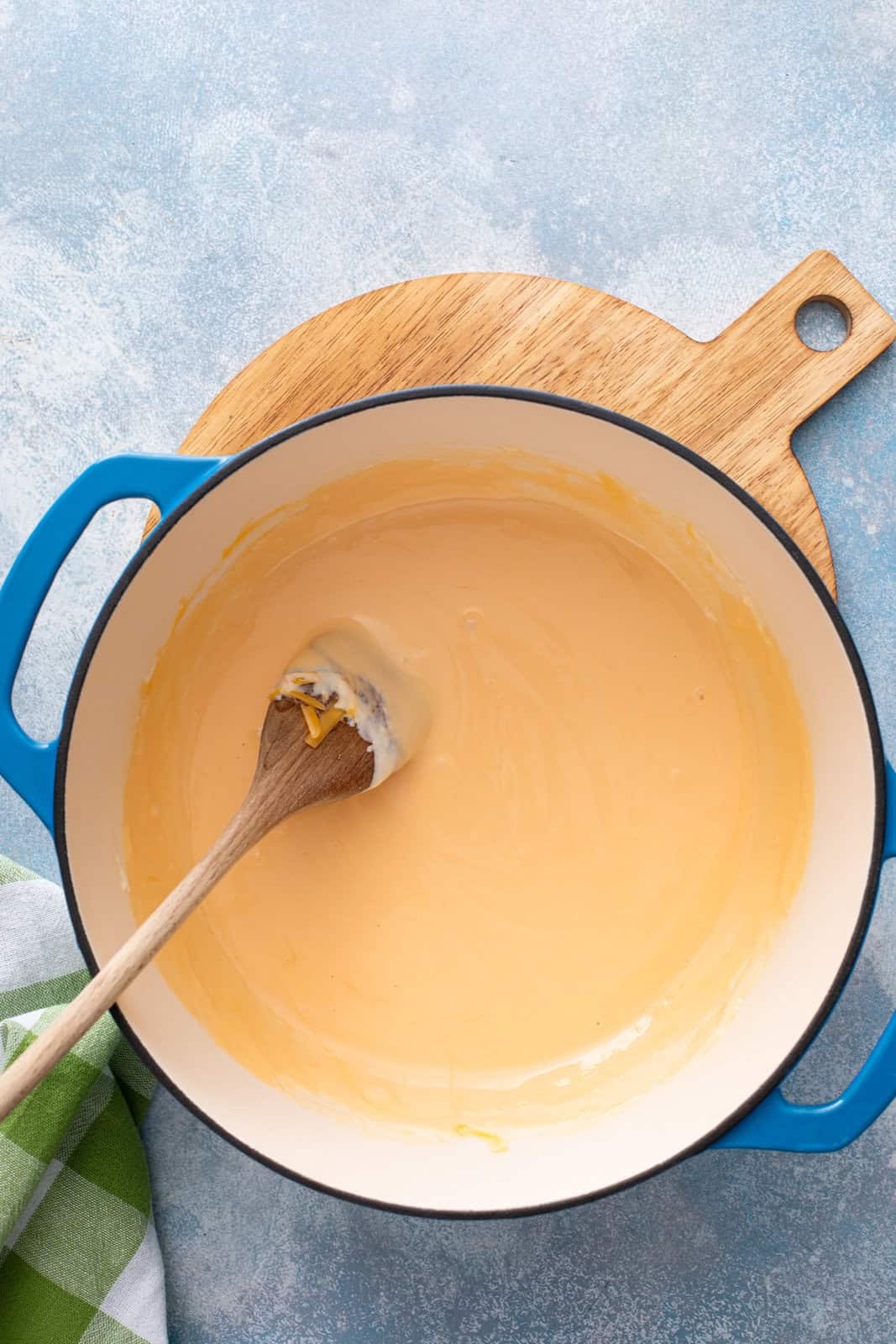 Cheese sauce for homemade shells and cheese in a blue dutch oven.