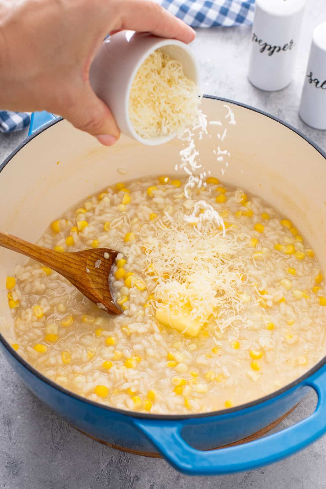 Butter and parmesan cheese being added to sweet corn risotto.