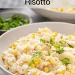 Close up of sweet corn risotto topped with green onion in a white bowl. Text overlay includes recipe name.