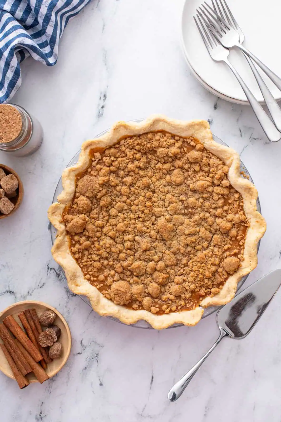 Baked and cooled sweet potato pie on a marble countertop.