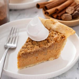 Plated slice of sweet potato pie with whipped cream.