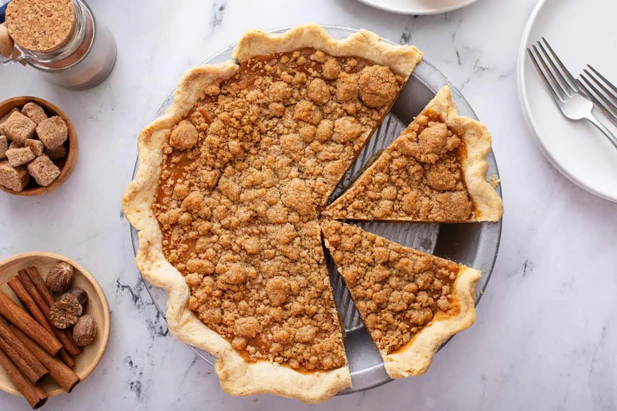 Overhead view of sliced streusel-topped sweet potato pie in a pie plate.