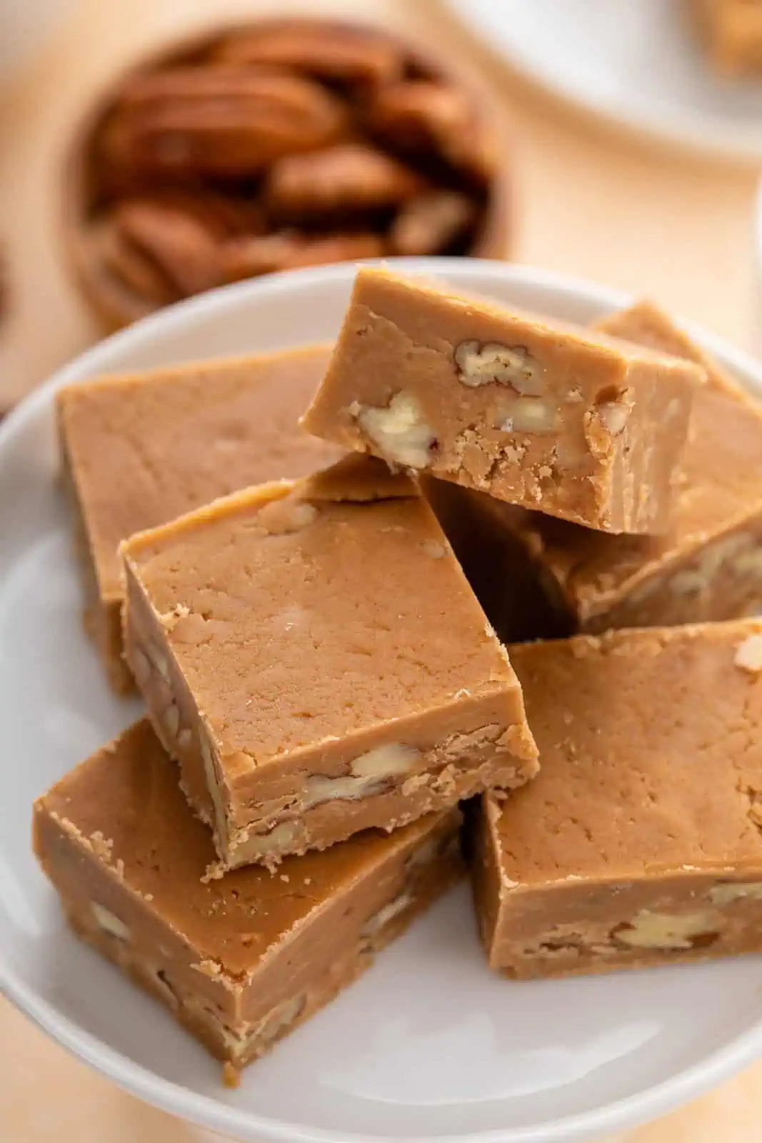 Close up view of pieces of brown sugar fudge on a white stand.