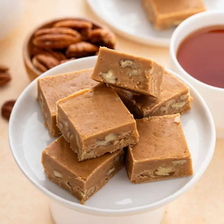 Several pieces of brown sugar fudge on a small white cupcake stand.