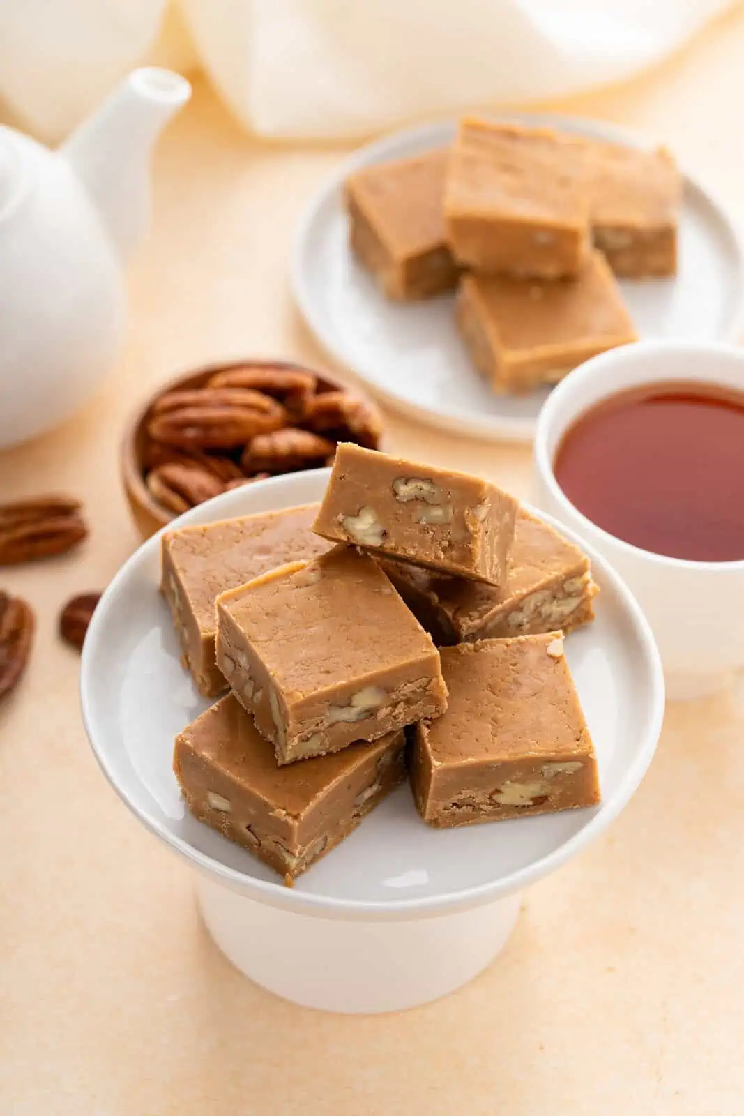 Pieces of brown sugar fudge on a small white cake stand.