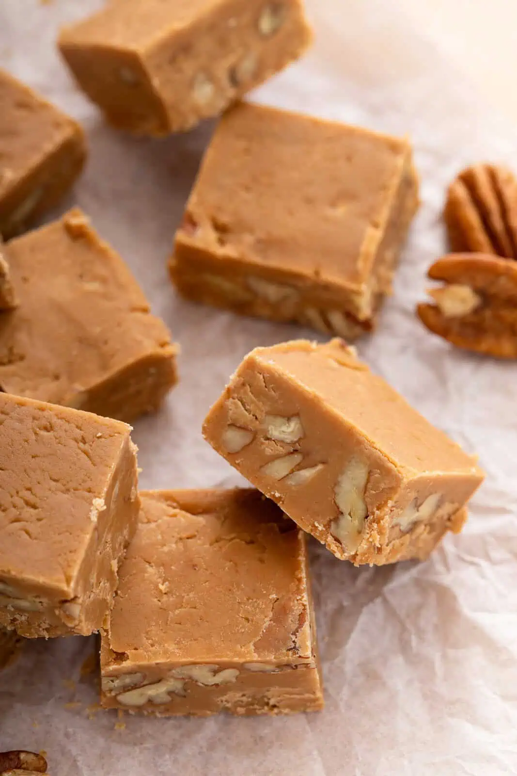 Side view of a piece of brown sugar fudge to show the nuts in the middle.