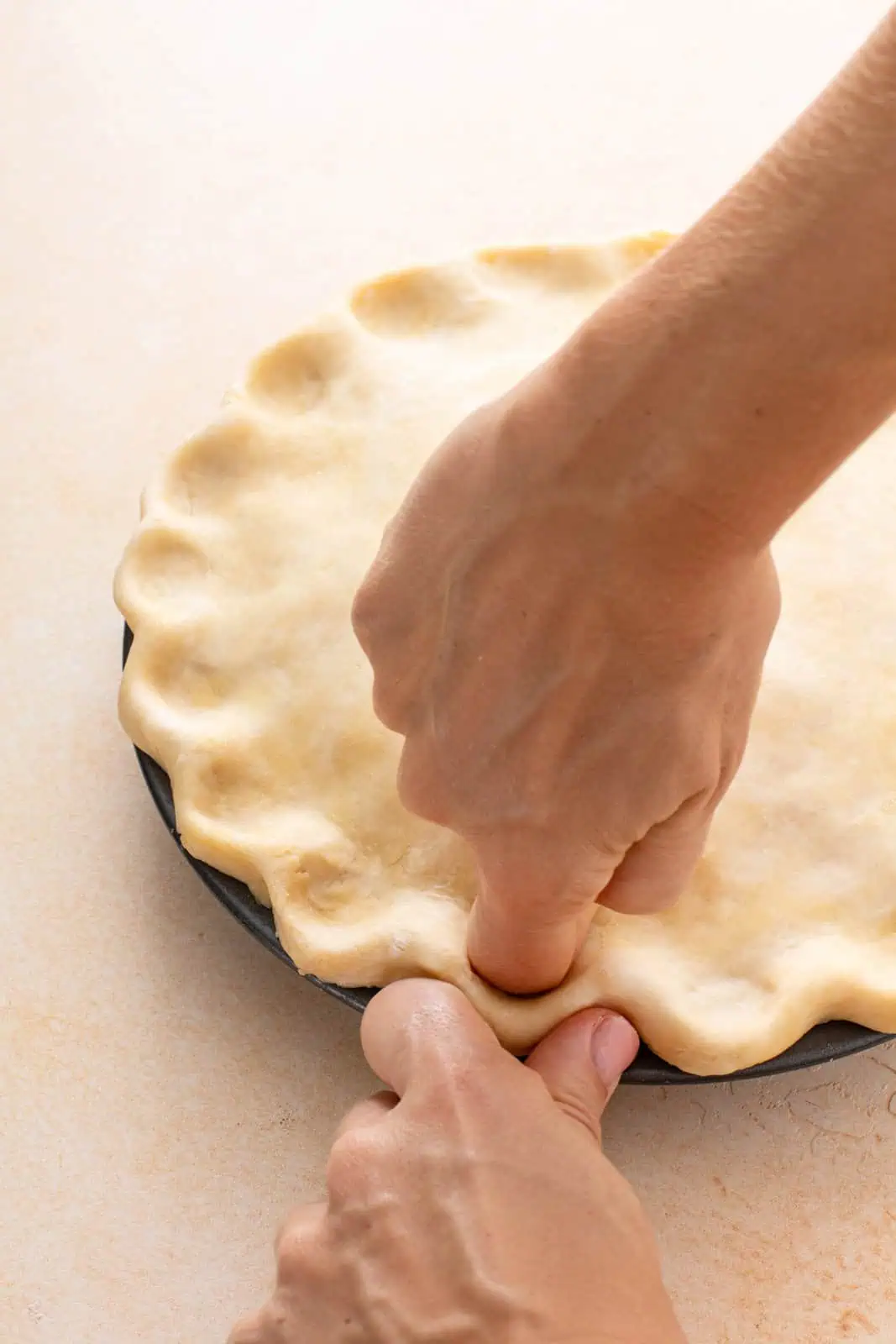 Hand crimping the edges of a pie.