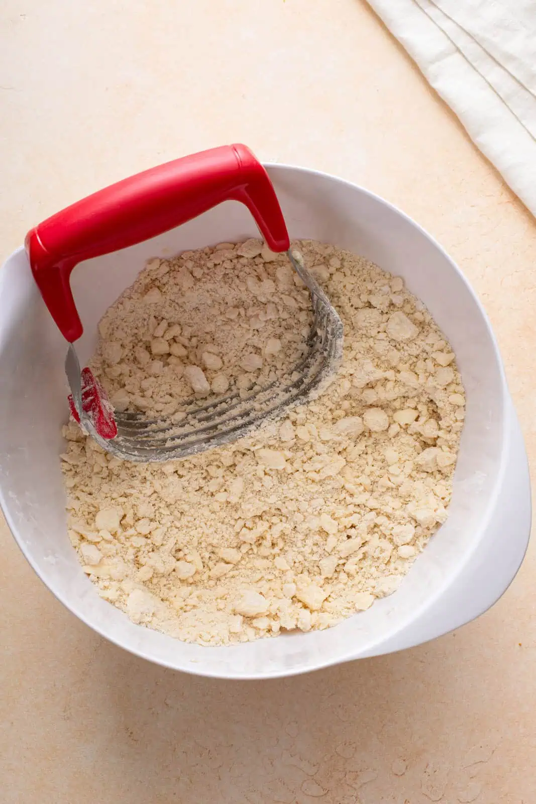 Butter and shortening cut into flour in a white bowl.