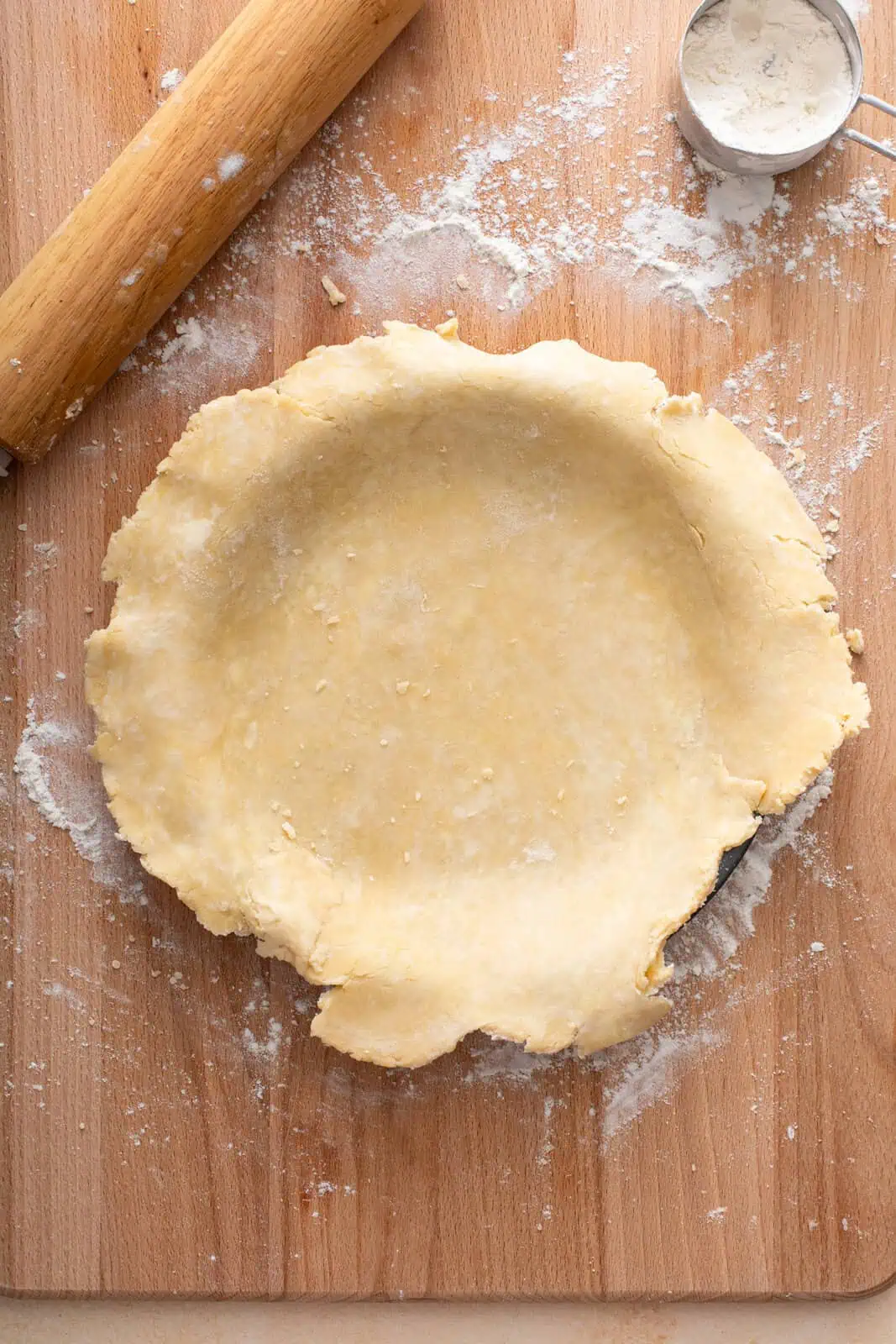 Rolled out pie dough set into a pie plate.