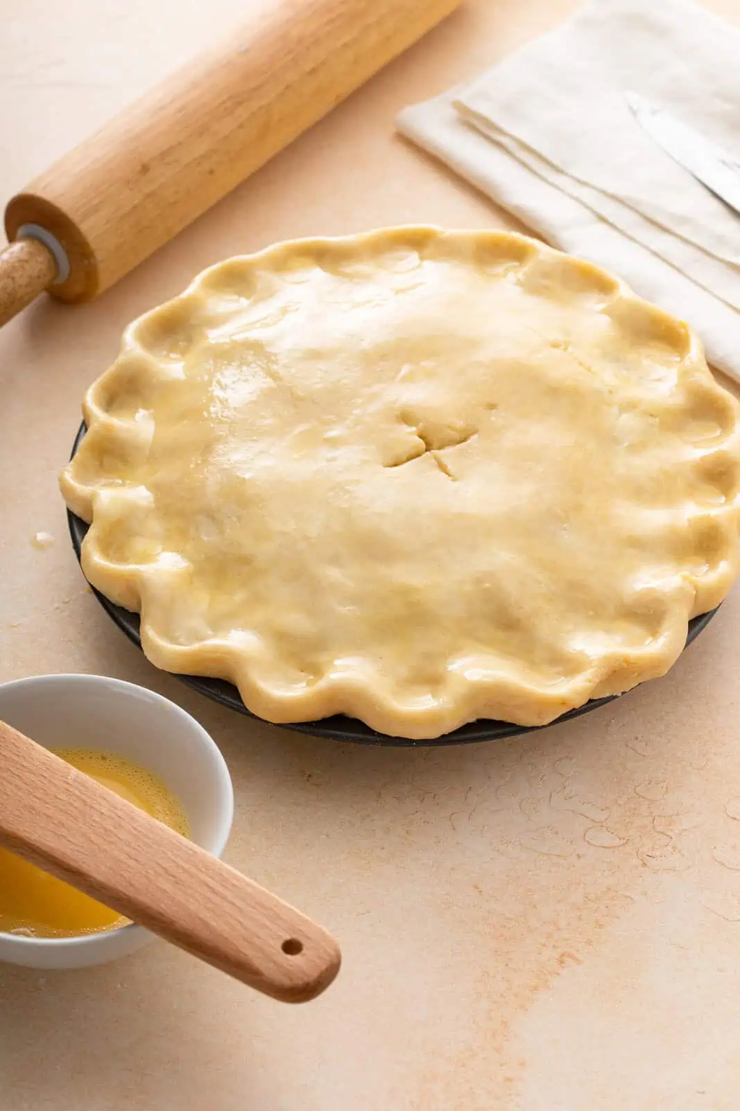 Unbaked pie, assembled and ready to be baked, set on a countertop.