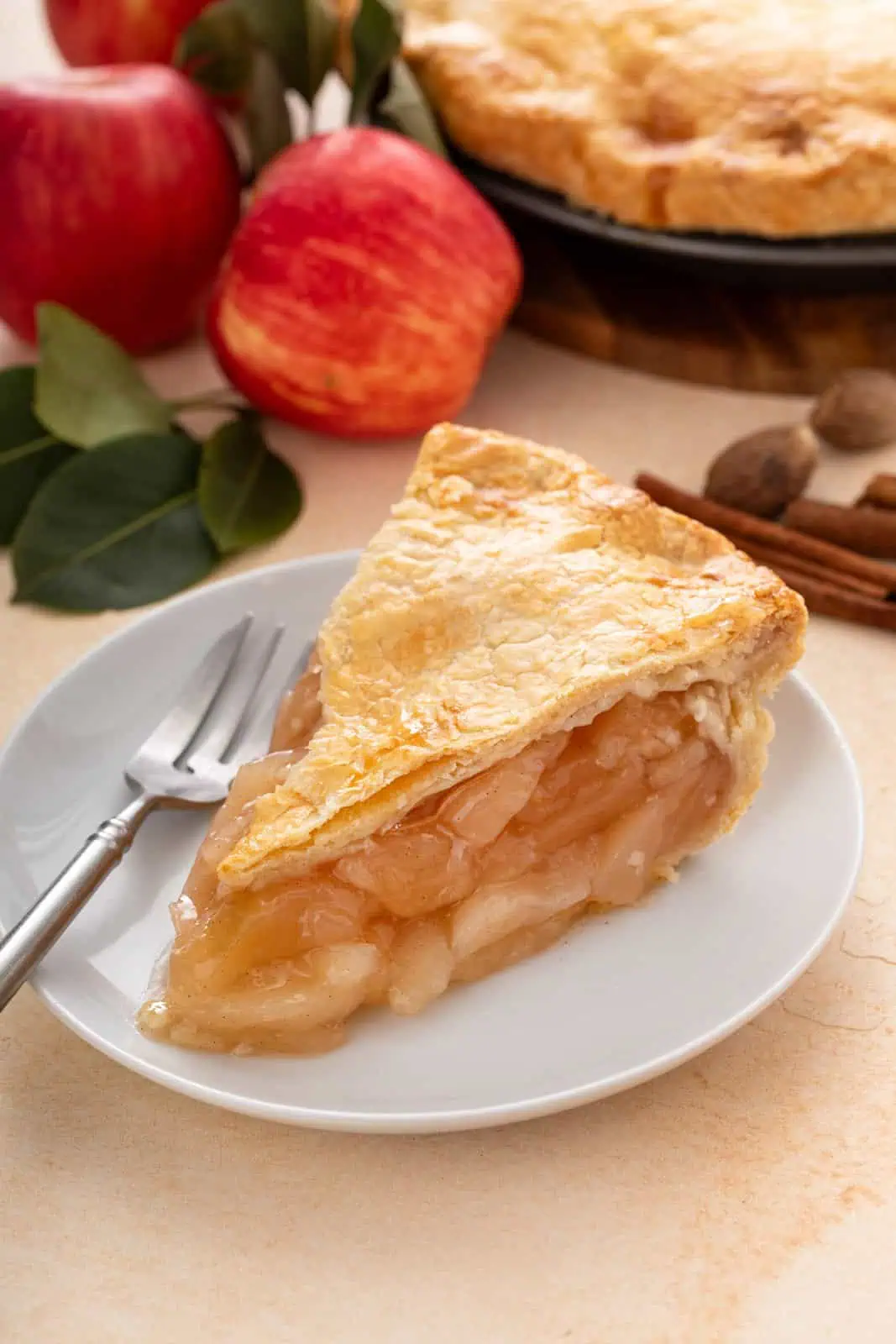 Slice of apple pie on a white plate.