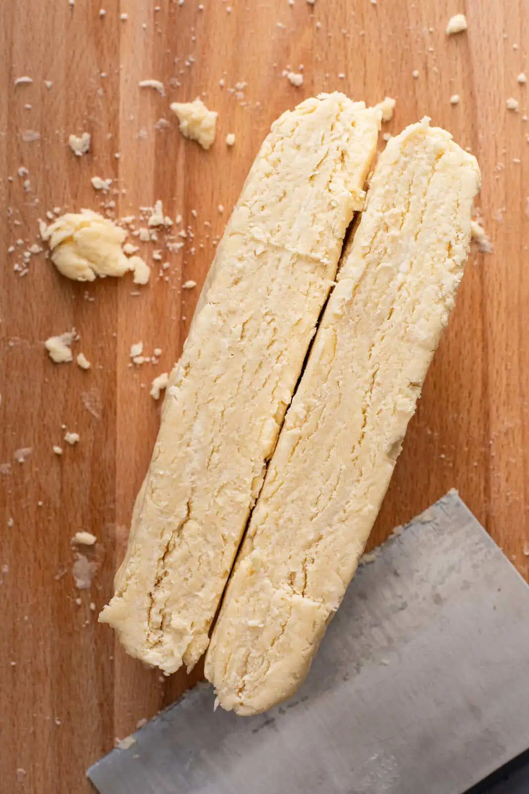 Pie dough cut in half to show the texture of the dough before rolling.