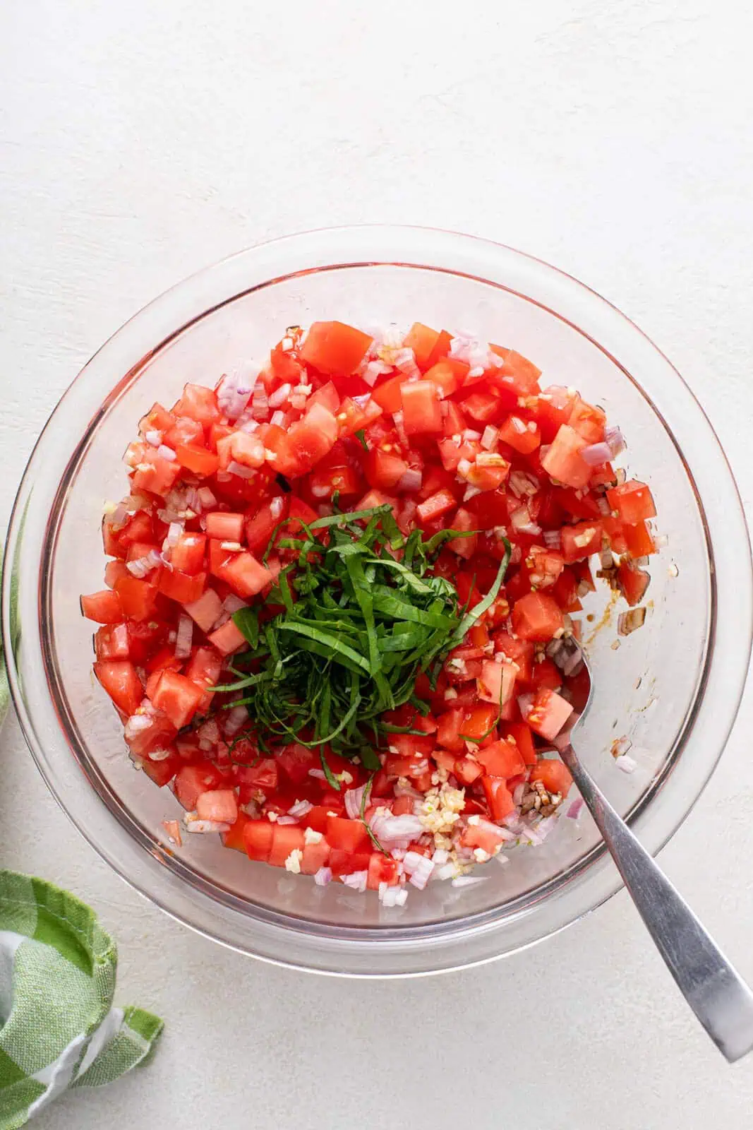 Ingredients for tomato bruschetta topping in a glass bowl.