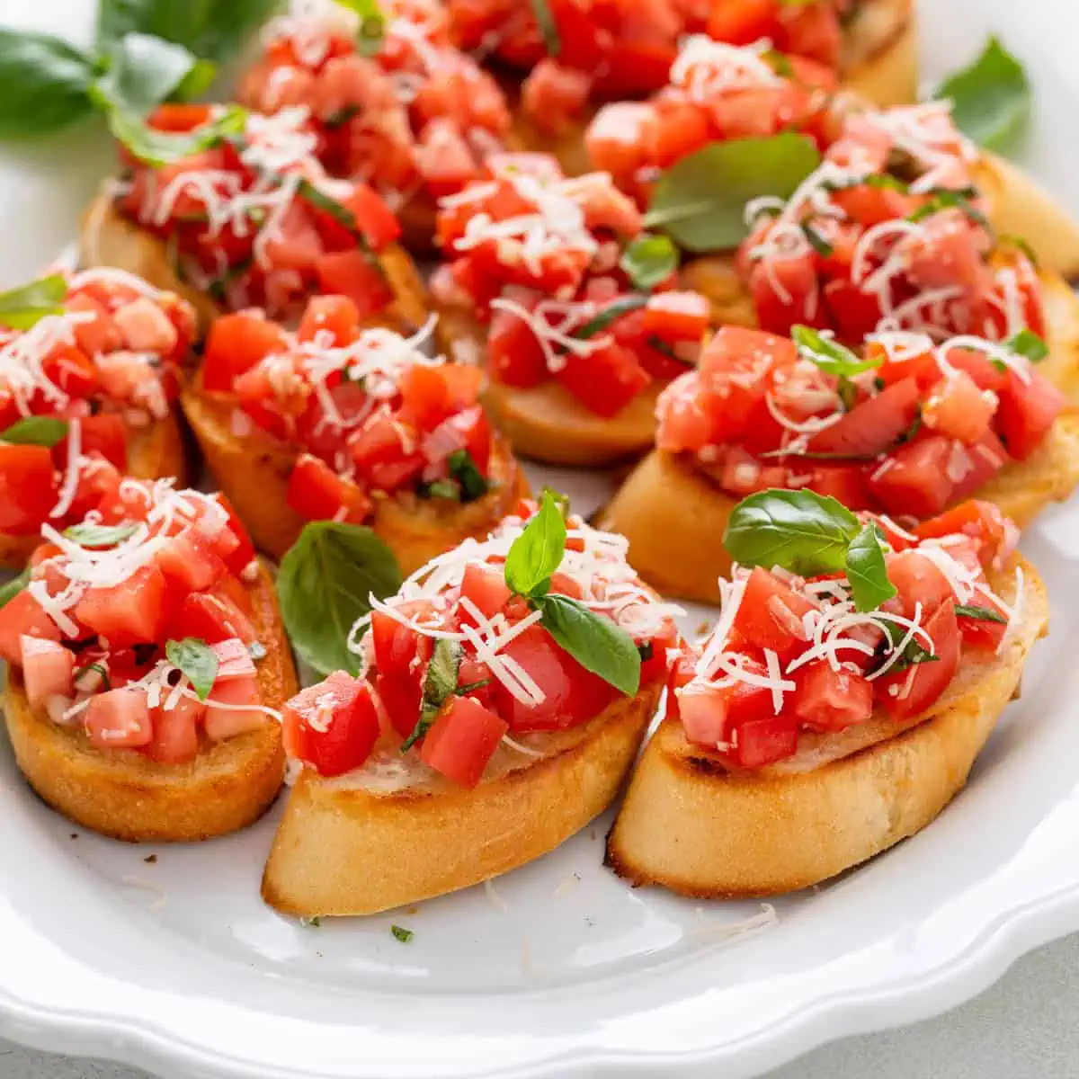 Classic tomato bruschetta on a white platter.