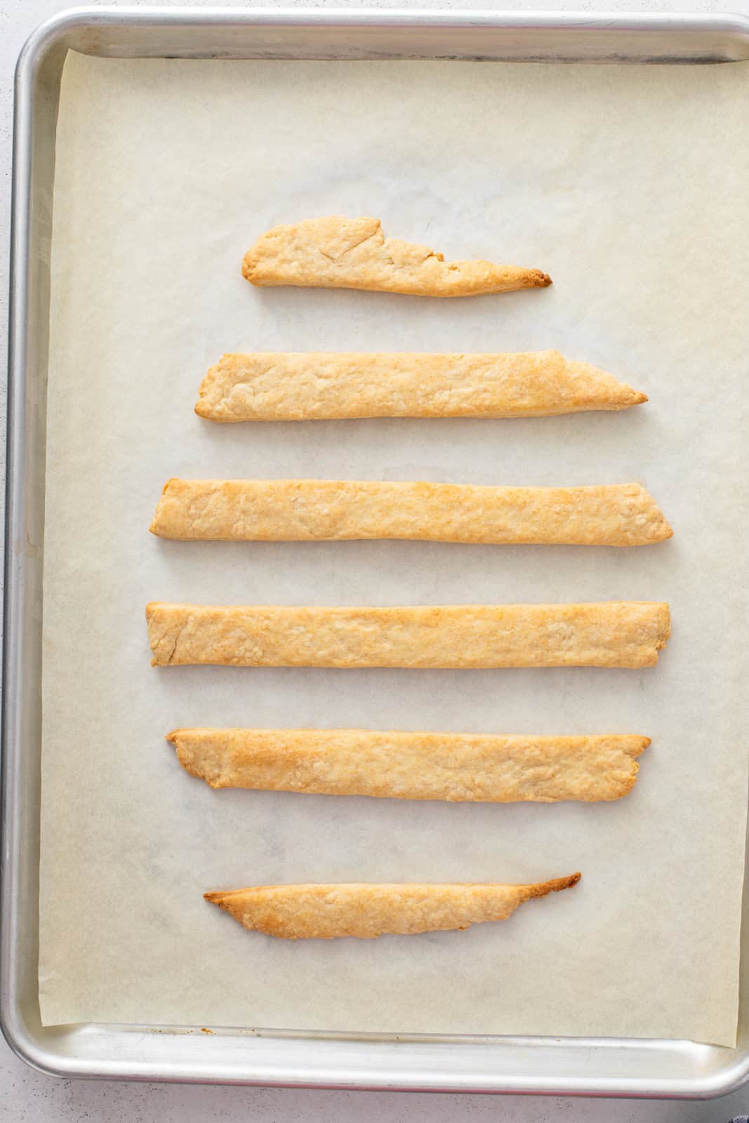 Baked strips of pastry dough on a baking sheet.