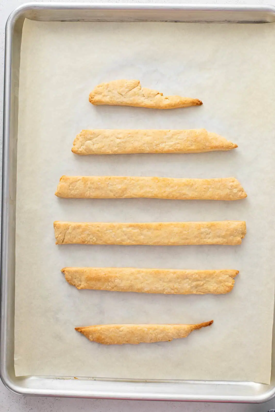 Baked strips of pastry dough on a baking sheet.