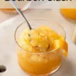 Spoon in a glass of bourbon slush garnished with an orange twist. Text overlay includes recipe name.