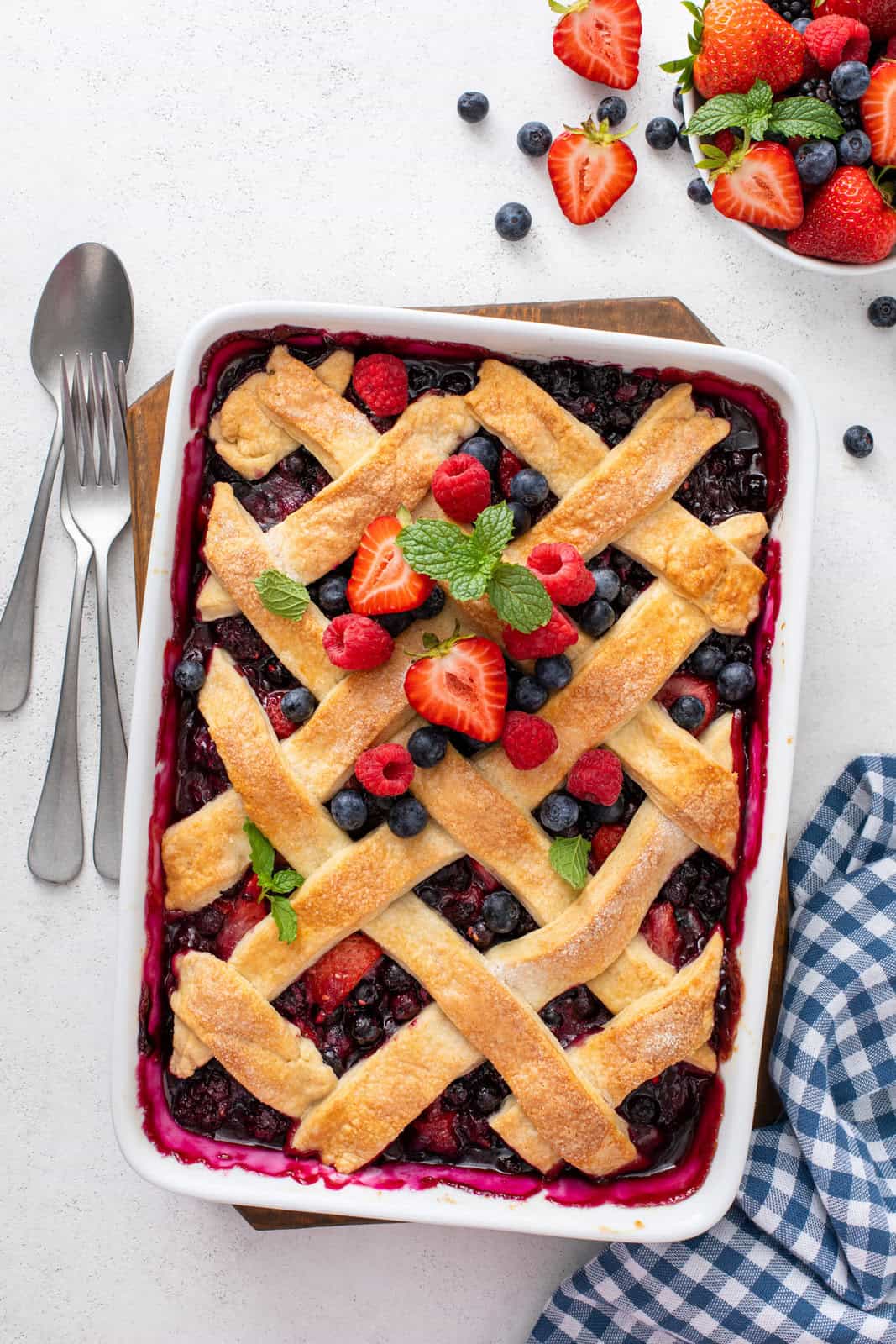 Overhead view of a pan of mixed berry cobbler topped with fresh berries.