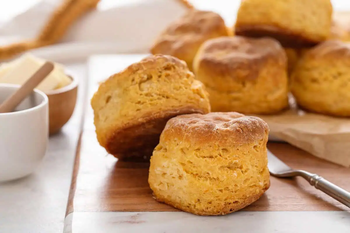 Close up of two sweet potato biscuits on a wooden and marble board.