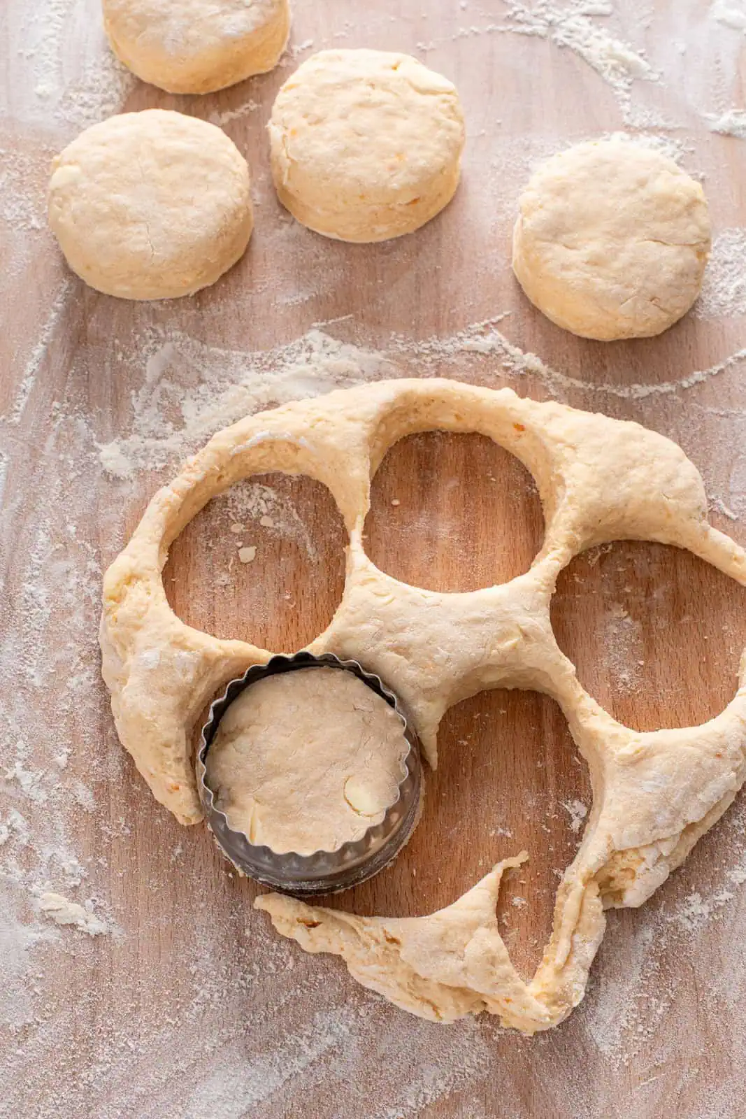 Sweet potato biscuits being cut out on a wooden board.