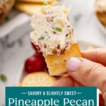 Hand holding up a cracker with a bite of pineapple cheese ball on it. Text overlay includes recipe name.