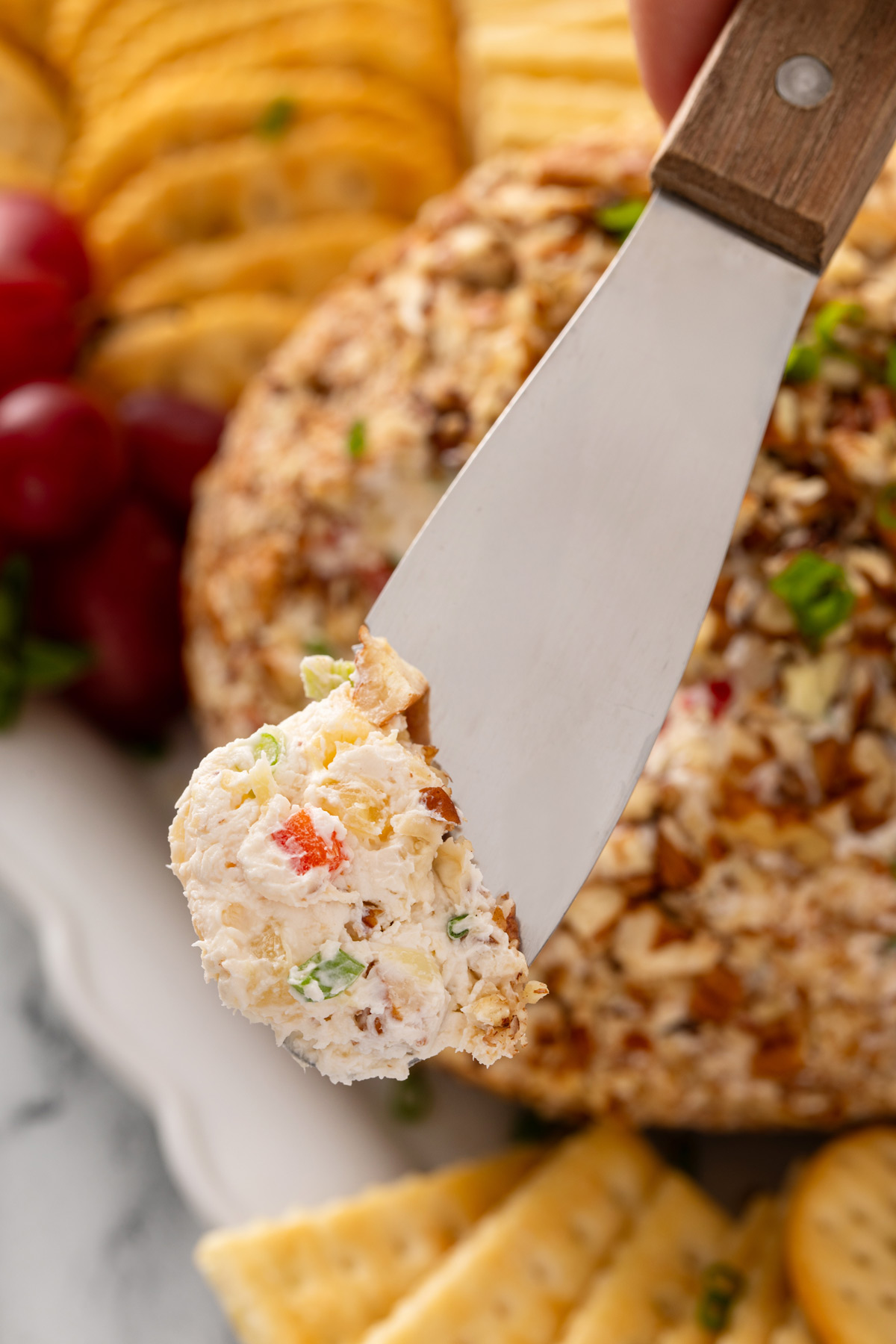 Bite of pineapple cheese ball on a cheese knife.