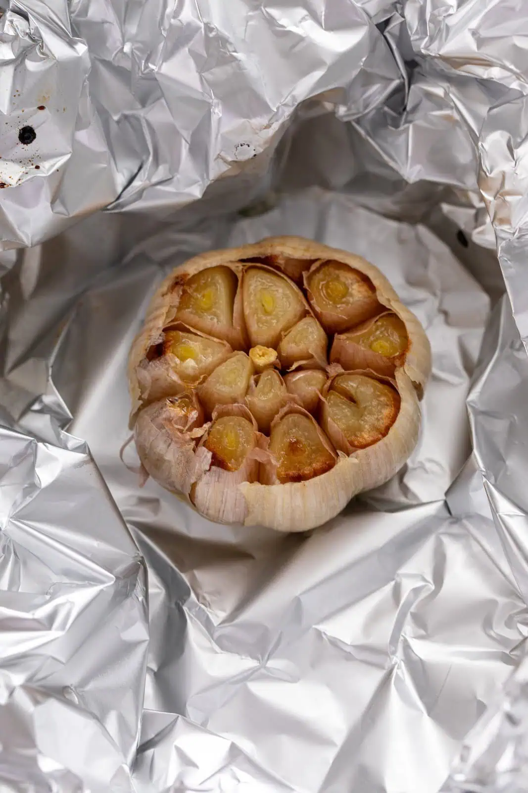 Roasted head of garlic on foil.