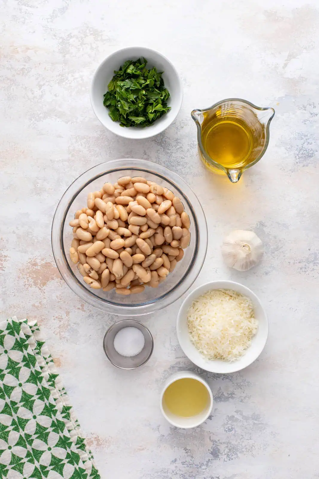 Ingredients for garlic parmesan white bean dip arranged on a countertop.