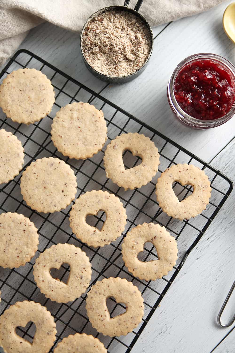 Raspberry Linzer Cookies sandwich raspberry jam between two almond cookies.