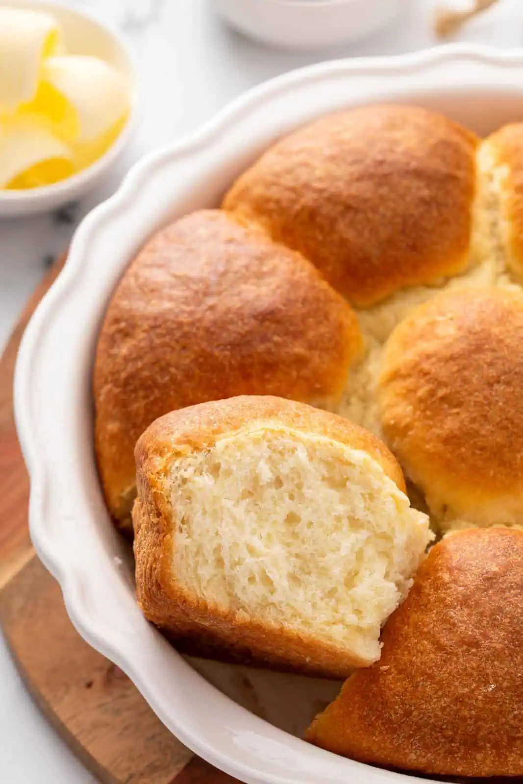 Pan of refrigerator rolls with one of the rolls cut from the pan and set on its side.