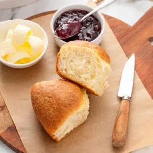 Two refrigerator rolls next to butter and jam.