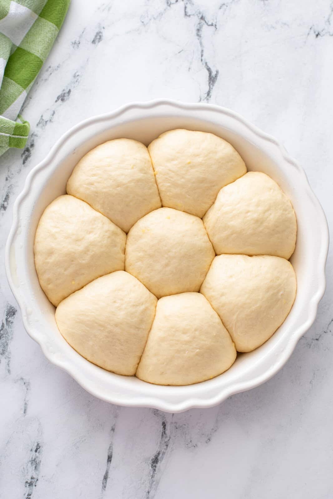 Pan of risen refrigerator rolls ready to go in the oven.