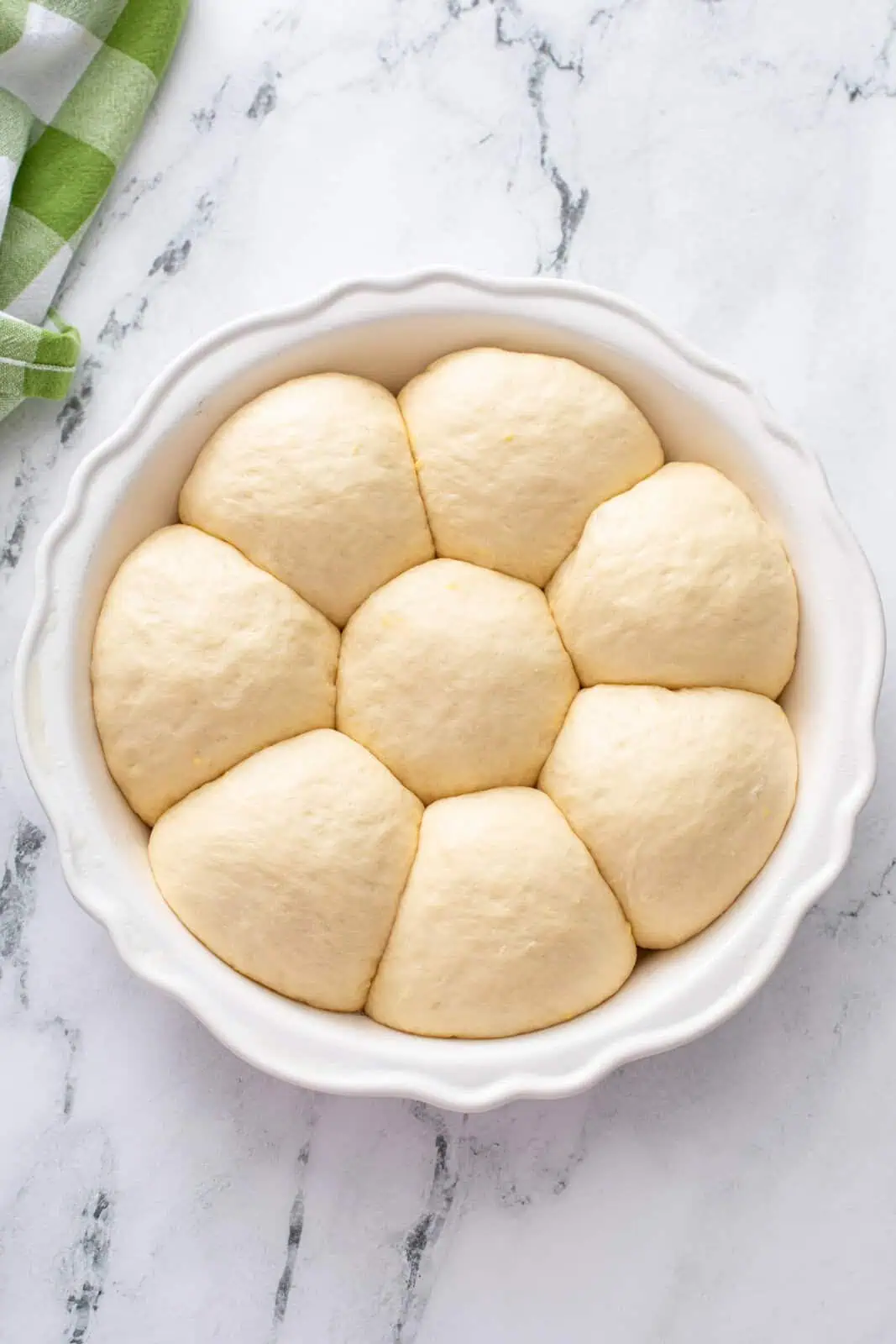 Pan of risen refrigerator rolls ready to go in the oven.