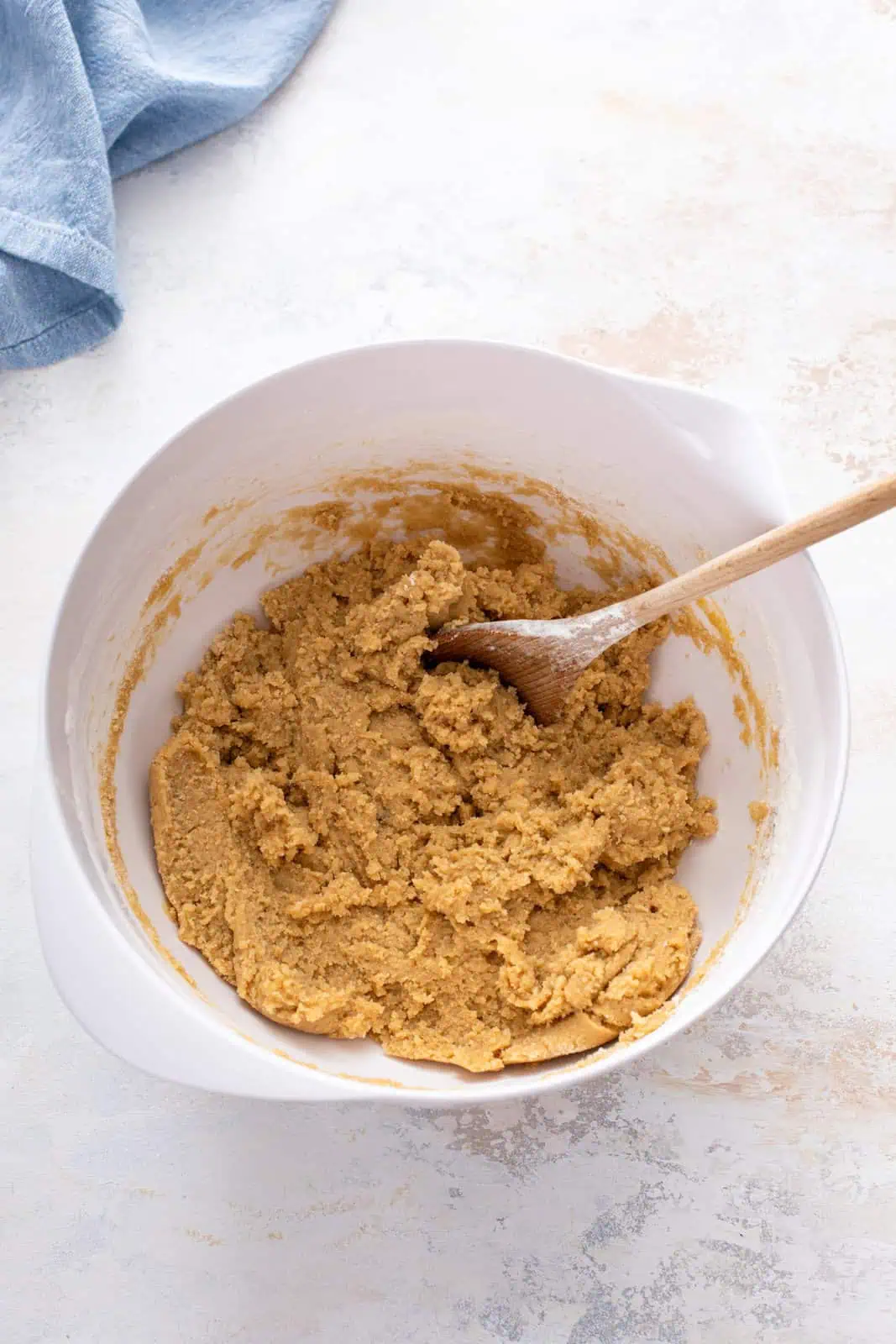 Dough for chocolate chipless cookies mixed in a white bowl.