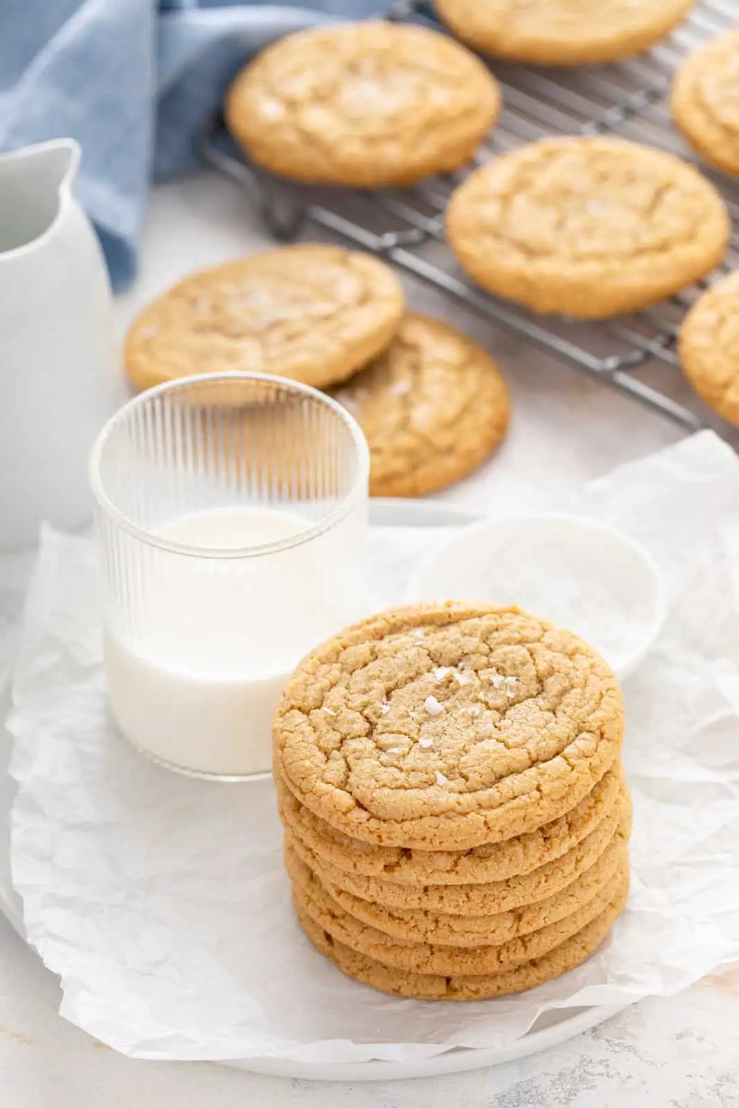 Stack of chocolate chipless cookies on a plate next to a glass of milk.