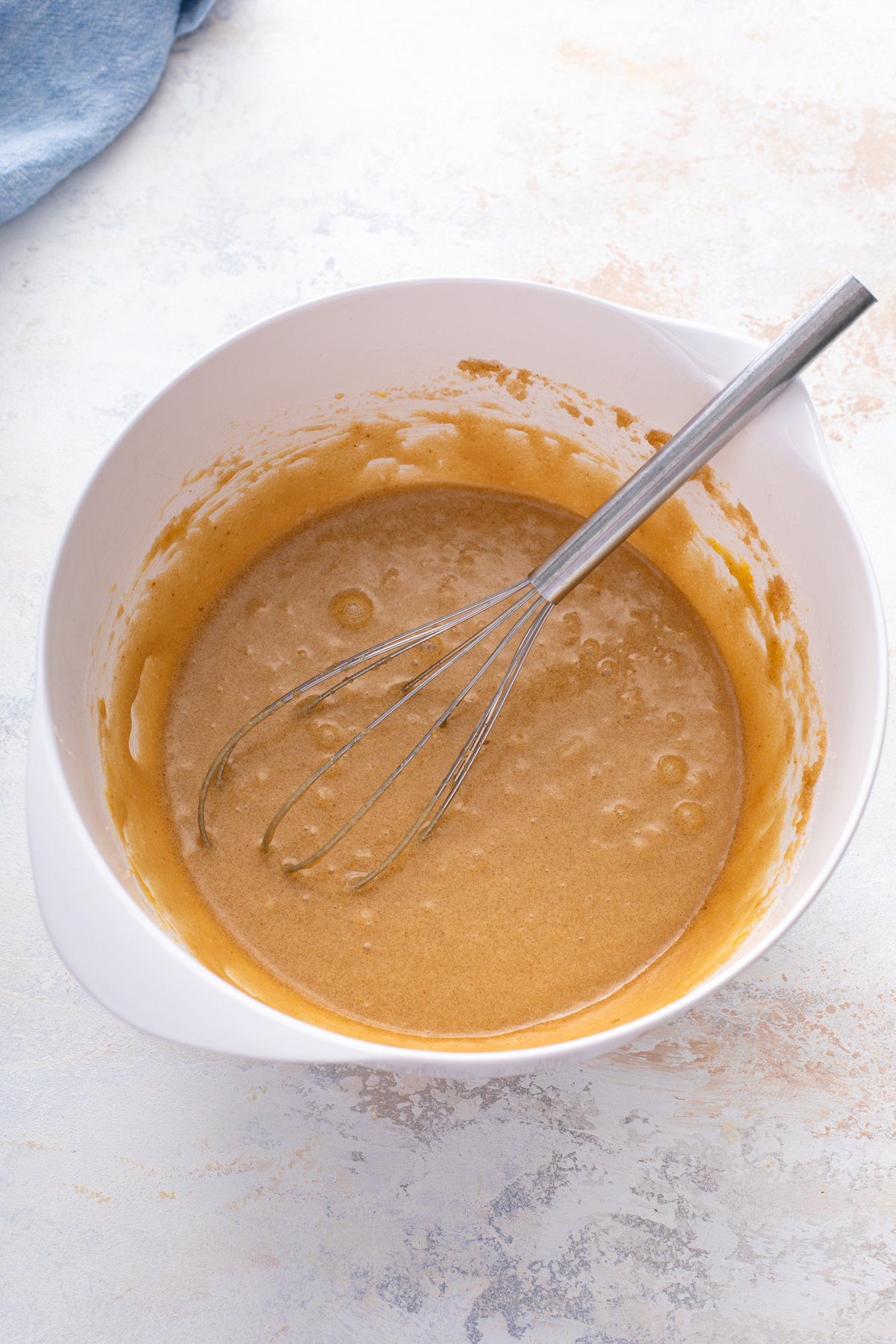 Wet ingredients for chocolate chipless cookies whisked in a mixing bowl.