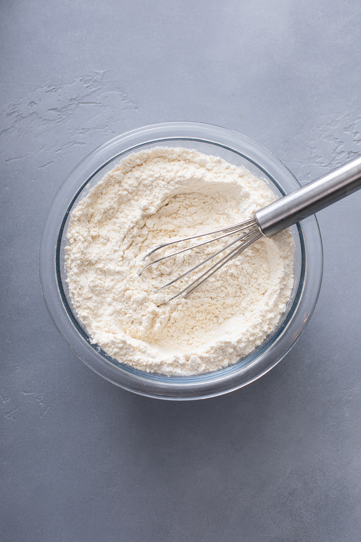 Dry ingredients for sour cream coffee cake whisked in a glass bowl.