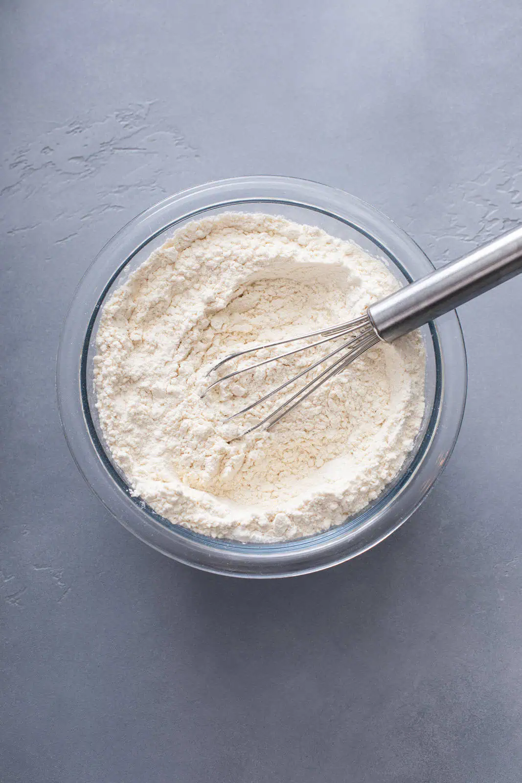 Dry ingredients for sour cream coffee cake whisked in a glass bowl.