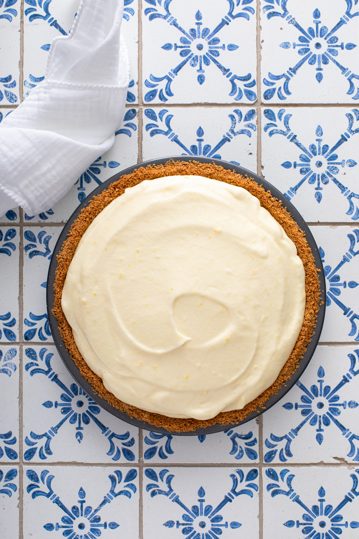 Assembled lemon chiffon pie on a blue and white countertop.